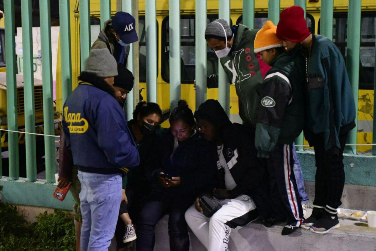 $!Migrantes miran las noticias en un celular.