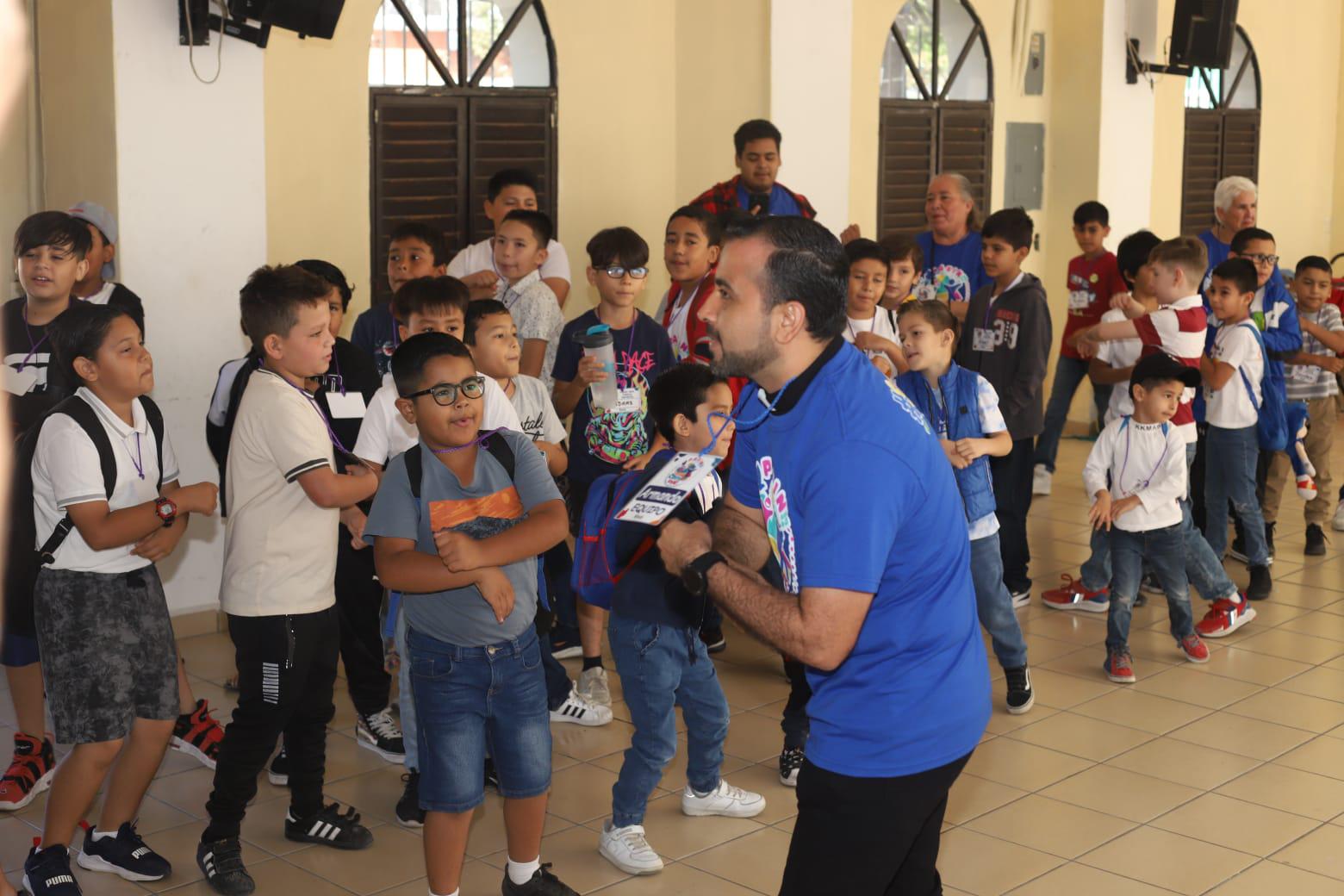 $!El Padre Armando Durán, coordinador del evento, durante la actividad de canto con los pequeños.