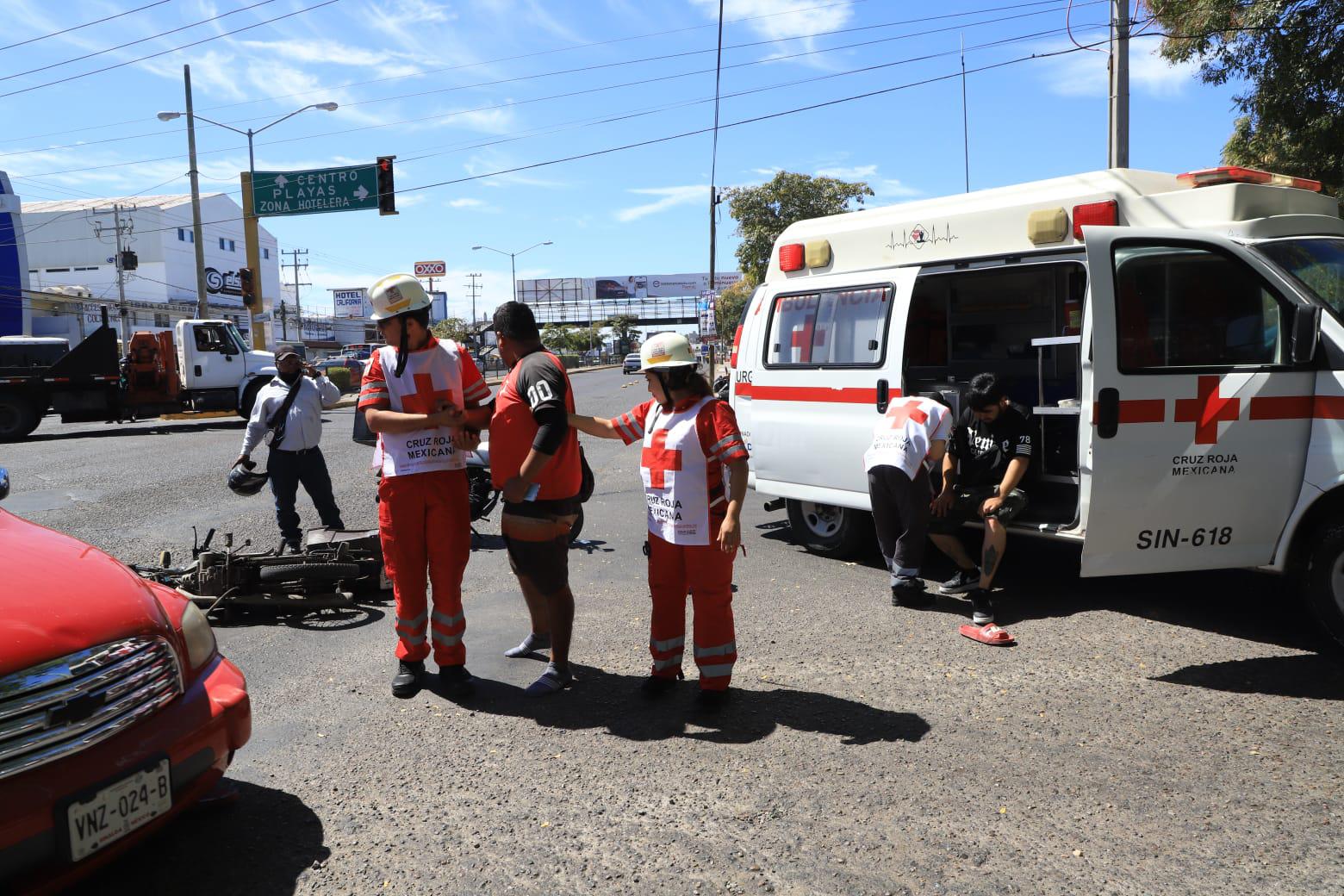 $!Conductor de auto se pasa el rojo y derriba a dos motociclistas en Mazatlán