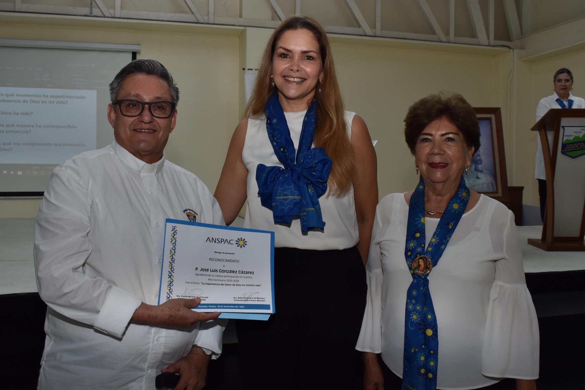 $!El Padre José Luis González Cazárez recibe el diploma de manos de Imelda Morales de Chicuate, presidenta de Anspac Mazatlán en compañía de Lucy Soto de Calleros.