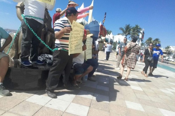 Inician vendedores ambulantes huelga de hambre y se encadenan a Monumento a la Familia