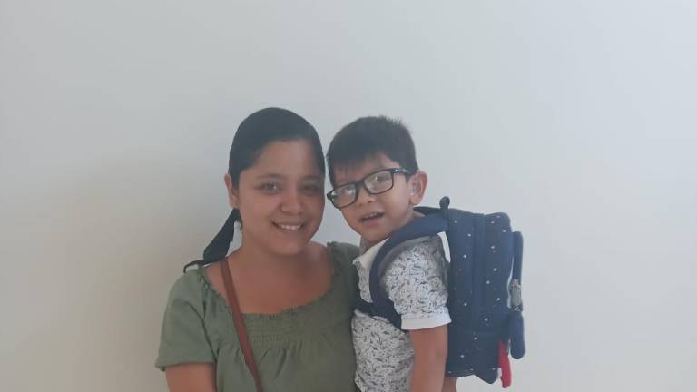 Lupita Valdez carga a su pequeño hijo Erick, de cuatro años de edad.