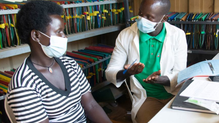 Un enfermero se reúne con una paciente seropositiva en un centro de salud del distrito de Namayingo, en Uganda.