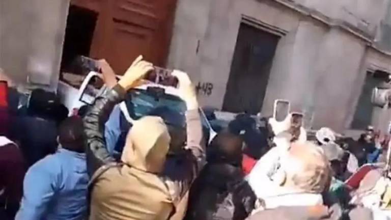 Estudiantes normalistas de Ayotzinapa derriban una puerta de Palacio Nacional.
