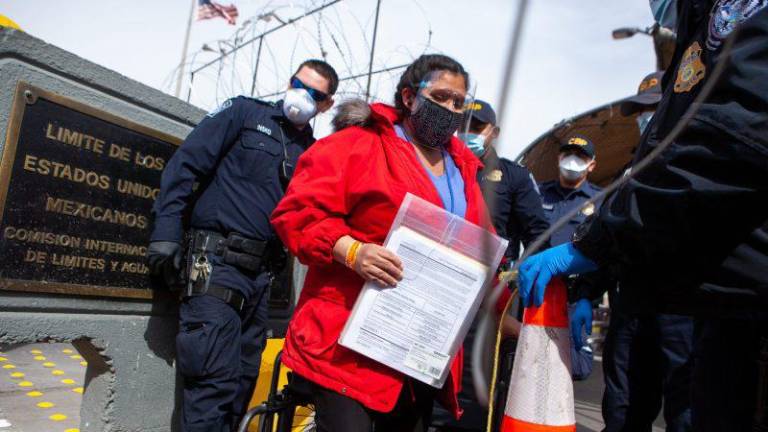 Una mujer inscrita en los MPP lleva sus documentos en una carpeta de plástico mientras cruza la frontera de Juárez a El Paso el 24 de marzo.