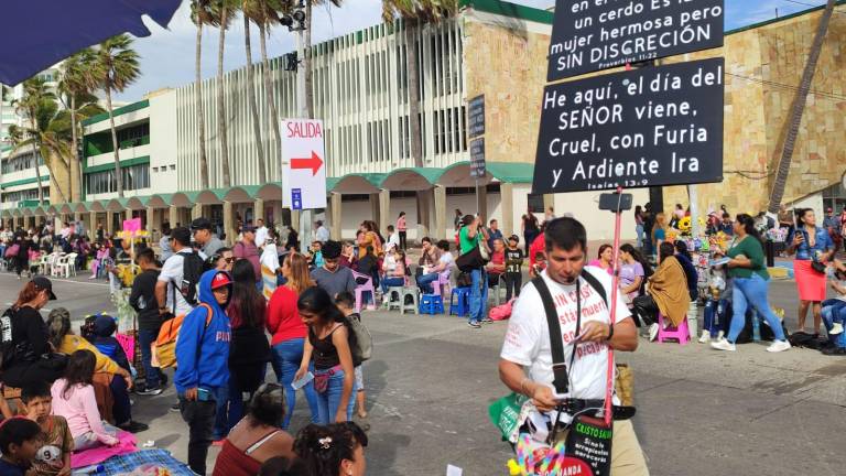 Dos personas cristianas se manifestan en el Monumento al Pescador en contra de los pecados en Carnaval.