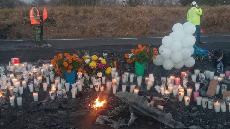 Cientos de velas, flores y globos cubrieron los restos carbonizados del autobús.