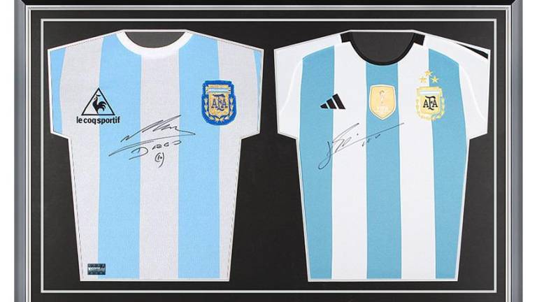 La camiseta autografiada por Maradona y Messi.