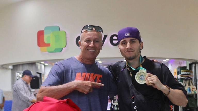 Marco Verde muestra su medalla acompañado de su papá Samuel, también ex olímpico.