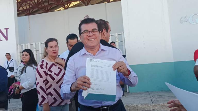 El Alcalde Édgar González muestra el documento que avala la compra de patrullas y camiones.
