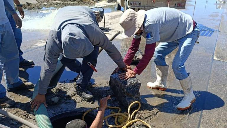 Personal de Jumapam saca piedras de la red de drenaje en Real del Valle.