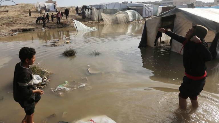 Los desplazados navegan por las aguas de las inundaciones en los campamentos donde viven.