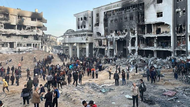 Varias personas se reúnen ante los restos del hospital Al Shifa, el mayor centro sanitario de Gaza.
