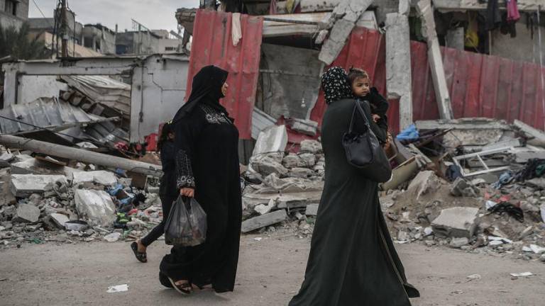 Mujeres supervivientes de los ataques israelíes caminan por las calles de la destruida ciudad de Gaza.