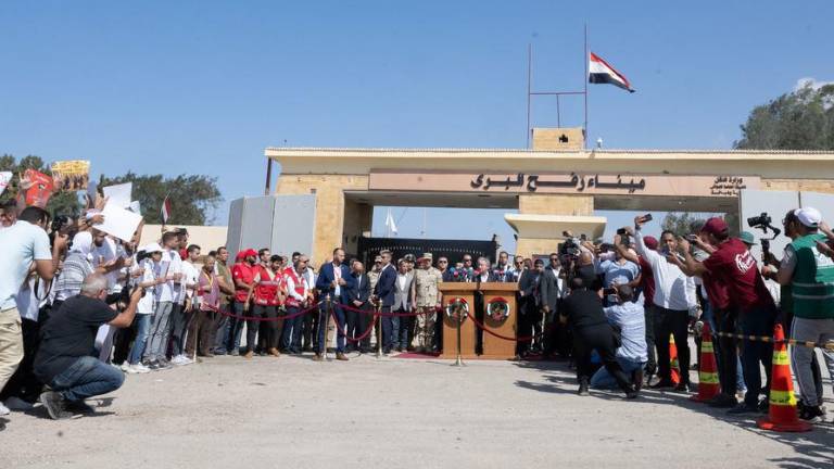 El Secretario General de la ONU, António Guterres, (en el podio a la izquierda) frente a la entrada a Gaza por el cruce de Rafah.