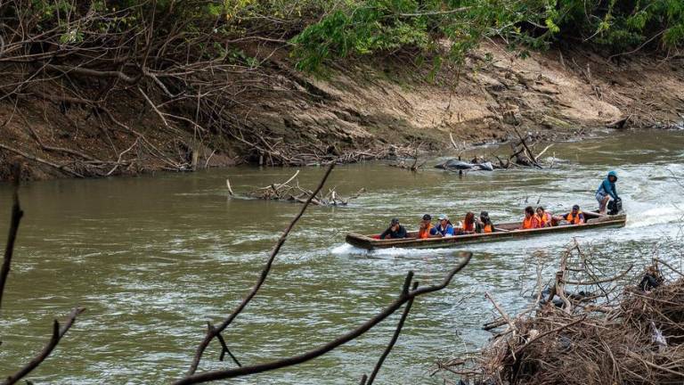 Niños migrantes cruzan un río en una embarcación en Panamá.