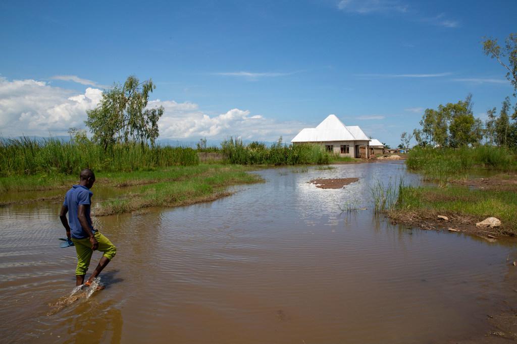 $!Un hombre camina entre las aguas de una inundación en Gatumba, Burundi, una zona que está recibiendo lluvias impredecibles debido al cambio climático