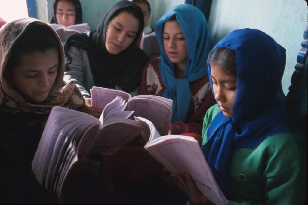 $!Unas niñas leen sus libros de texto en el centro educativo Dasht-e-Barchi de Kabul (Afganistán).
