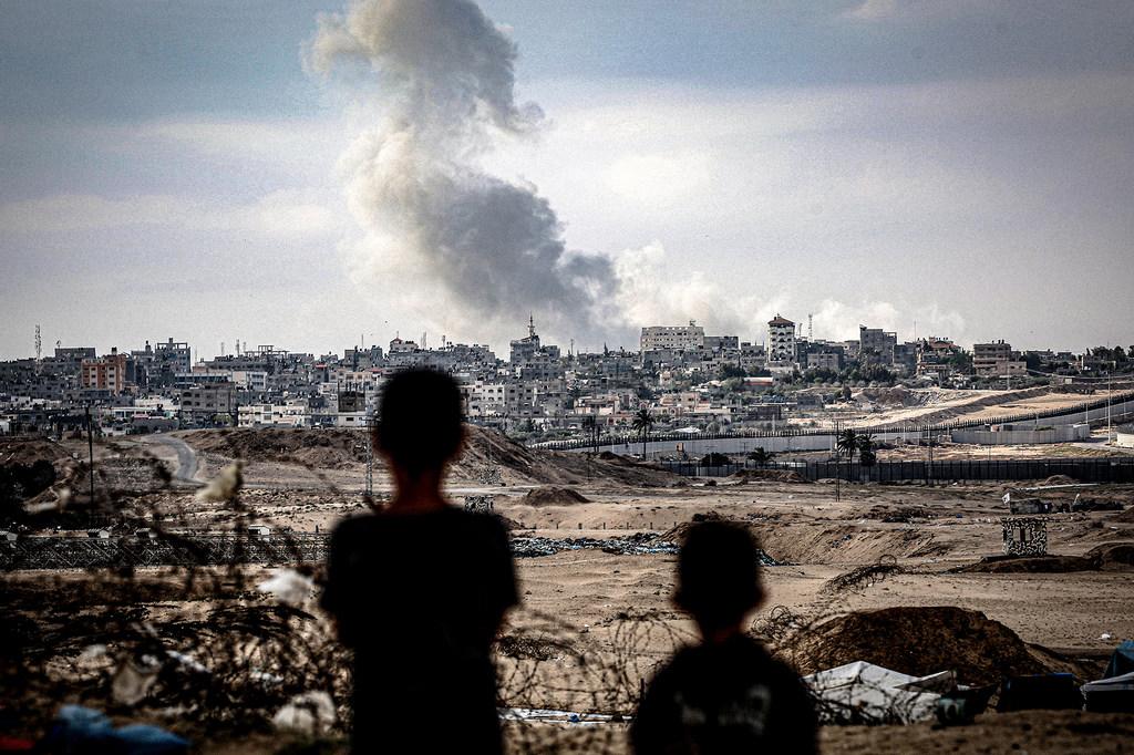 $!Dos niños observan columnas de humo tras un ataque aéreo sobre la ciudad de Gaza.