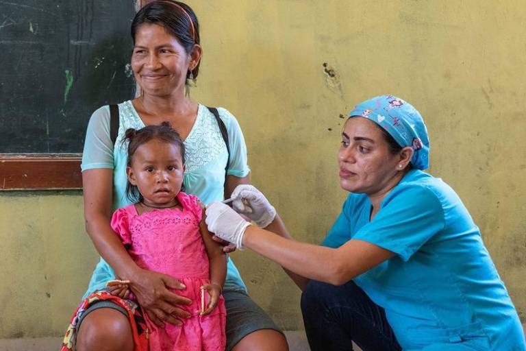 Una niña de dos años recibe la vacuna contra la gripe en un dispensario móvil de Loreto, Perú.