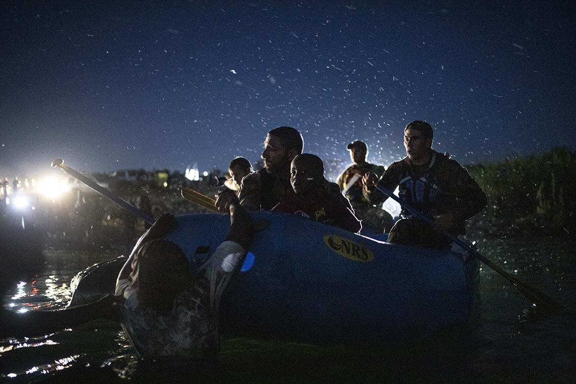 $!Un niño migrante es rescatado del Río Bravo por agentes de Estados Unidos, a bordo de una lancha, antes de que los menores pudieran ser arrastrados por la corriente en el lado estadounidense de la frontera entre Ciudad Acuña, México,.
