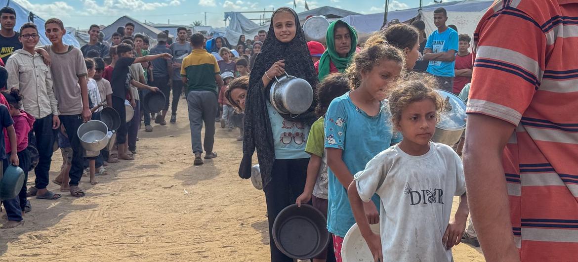 $!Antes del acuerdo de alto el fuego, los habitantes de Gaza hacen cola para recibir comida en un comedor comunitario en Deir al Balah.