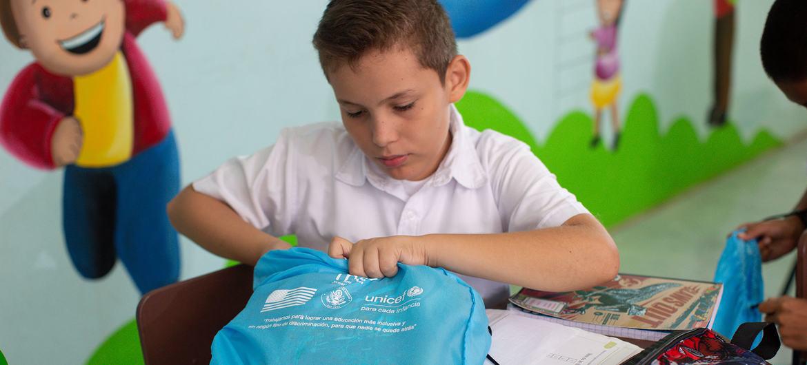 $!Juan Pablo Moreno (10) busca sus útiles dentro del bolso, que forma parte de los kits de aprendizaje donados por UNICEF para toda la población estudiantil que incluye un set de uniformes y materiales escolares.