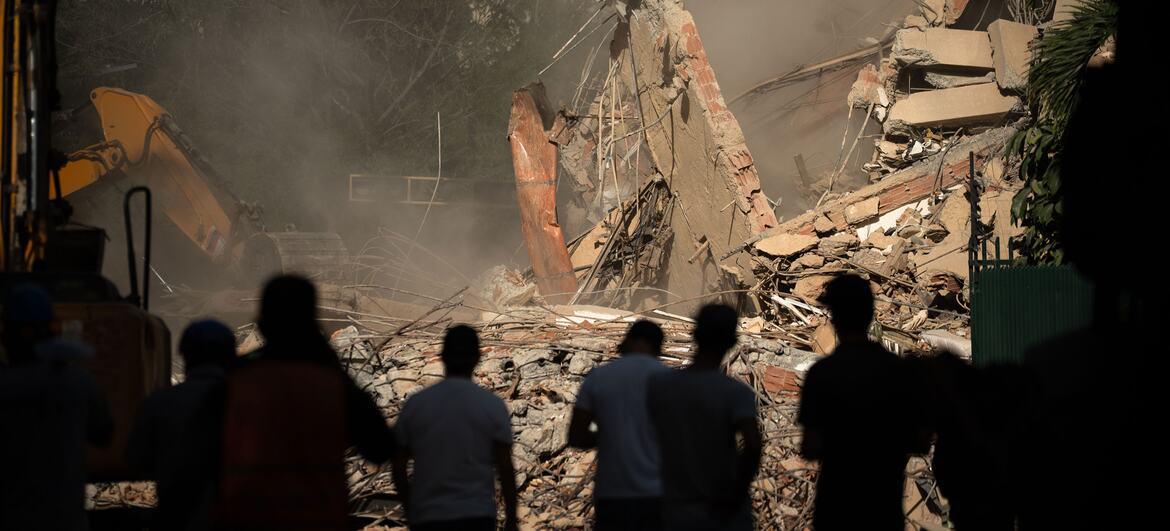 $!Los equipos de rescate observan cómo se retiran los escombros de un edificio derrumbado en Caracas, Venezuela.