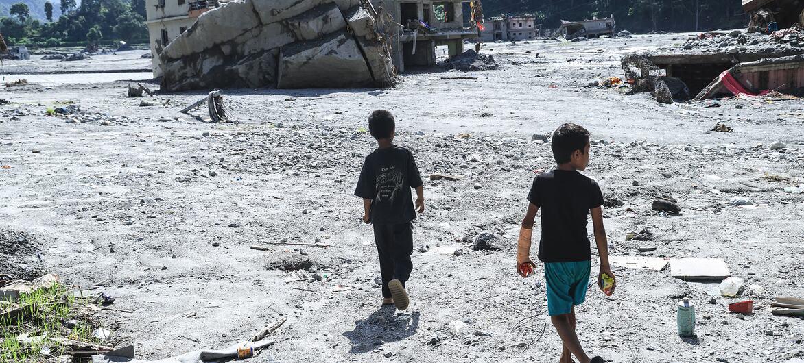 $!Niños caminan por el lugar donde se encontraba su escuela en el distrito de Nuwakot después de las devastadoras inundaciones que azotaron Nepal.