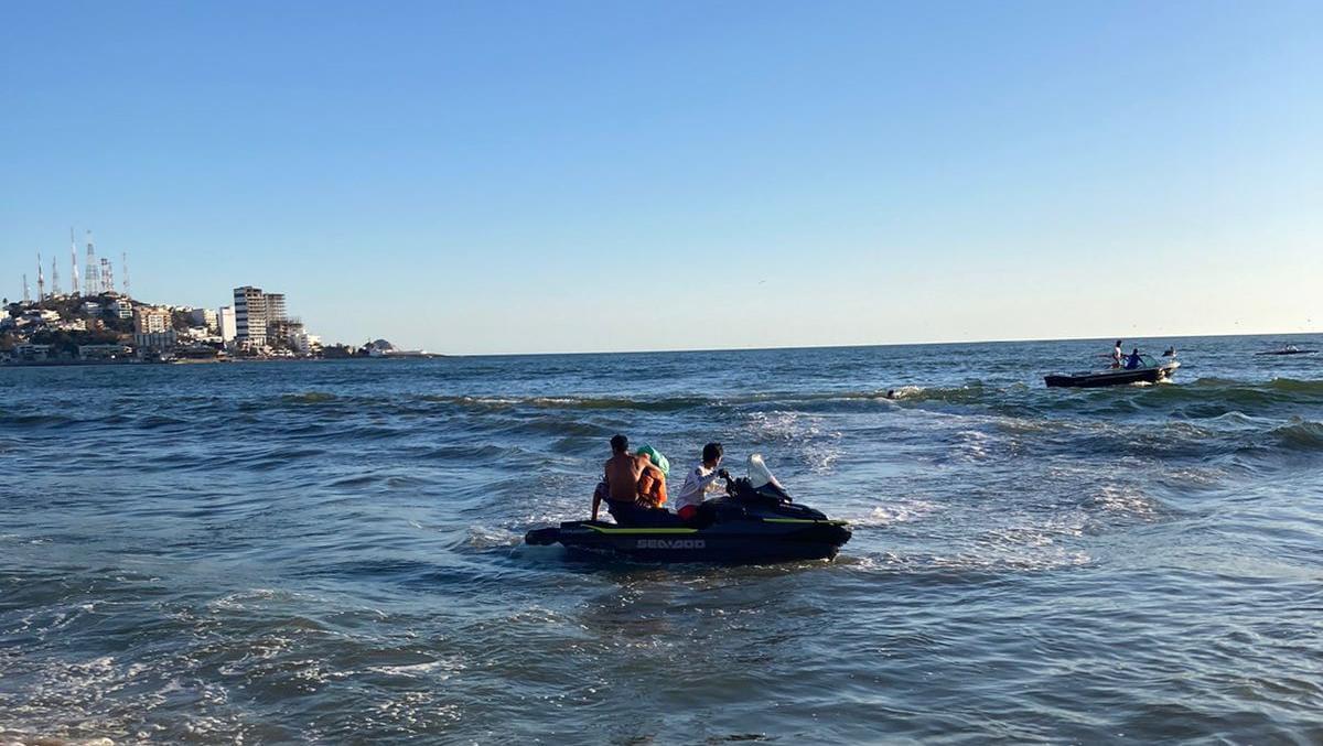 $!Cae al mar una pareja que viajaba en parachute; rescatan a 10 más que eran jalados por la resaca