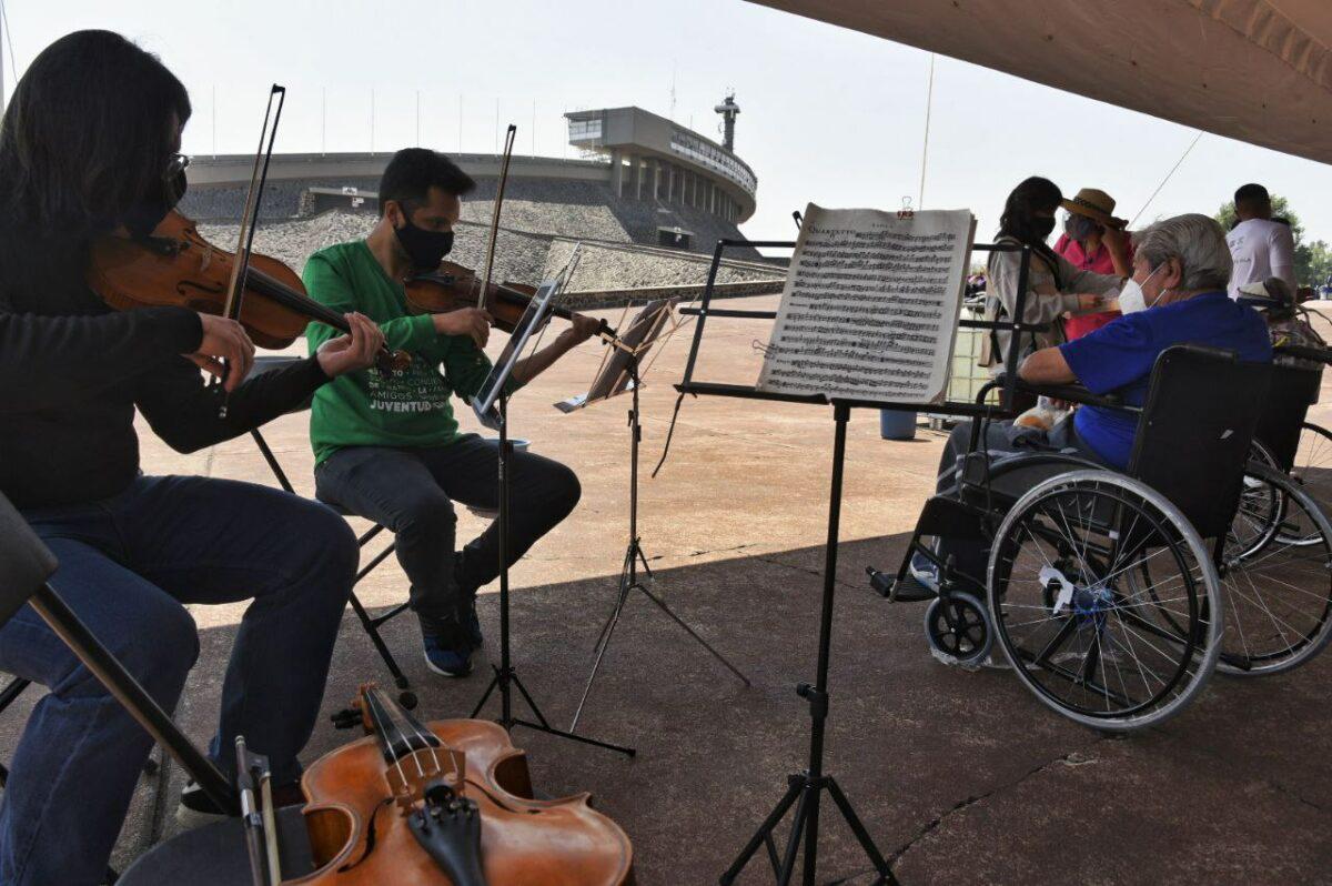 $!En el Estadio de Ciudad Universitaria, un grupo de jóvenes del Instituto de la Juventud amenizan con sus violines el área de observación.