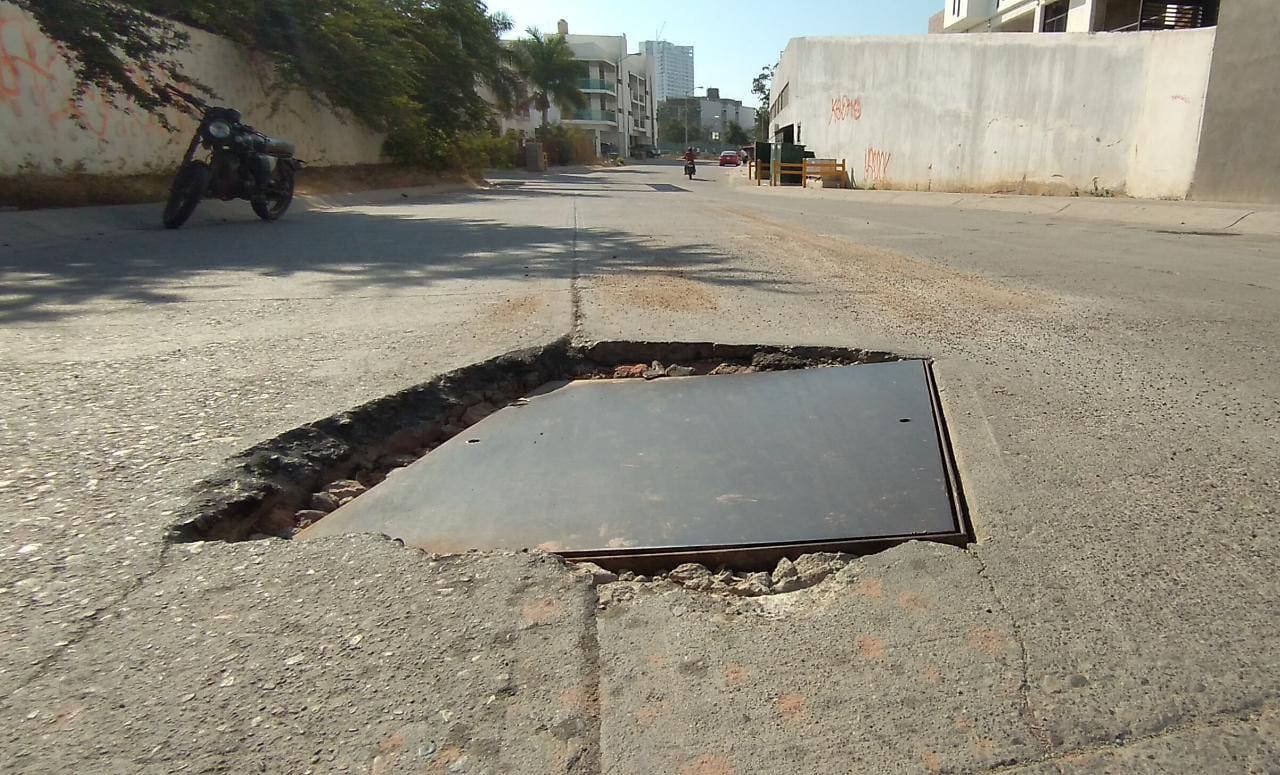 $!Los vehículos caen y se golpean en este pozo con tapadera hundida en calle Pez Vela y Camarón-Sábalo.