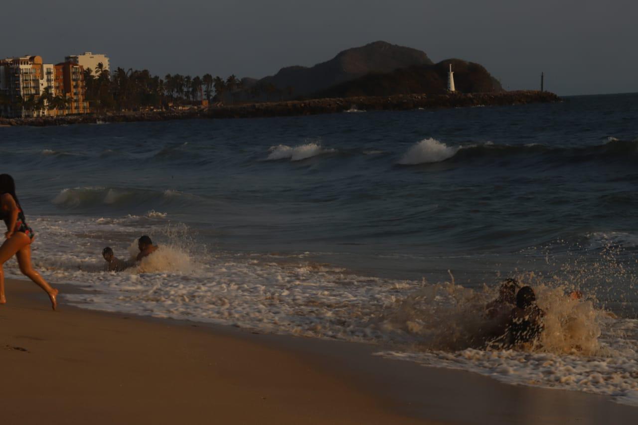$!Las personas se bañan en el mar en la orilla pese al fuerte oleaje.
