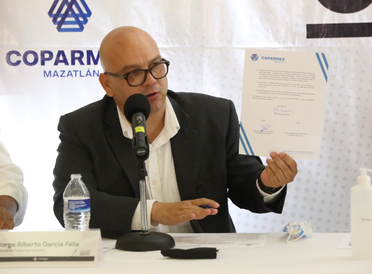 $!Jorge García Félix, presidente de Coparmex Mazatlán, muestra la carta compromiso firmada.