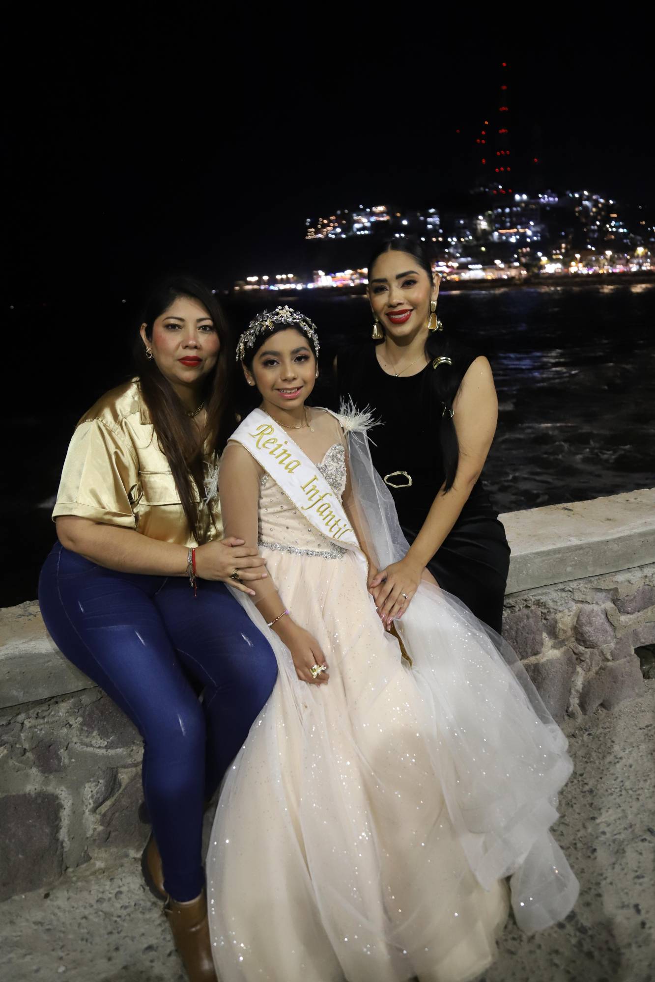 $!Eileen Cruz, Reina Infantil del Carnaval de Mazatlán 2026, entre su tía Zulema Corona y su mamá, Brenda Corona.