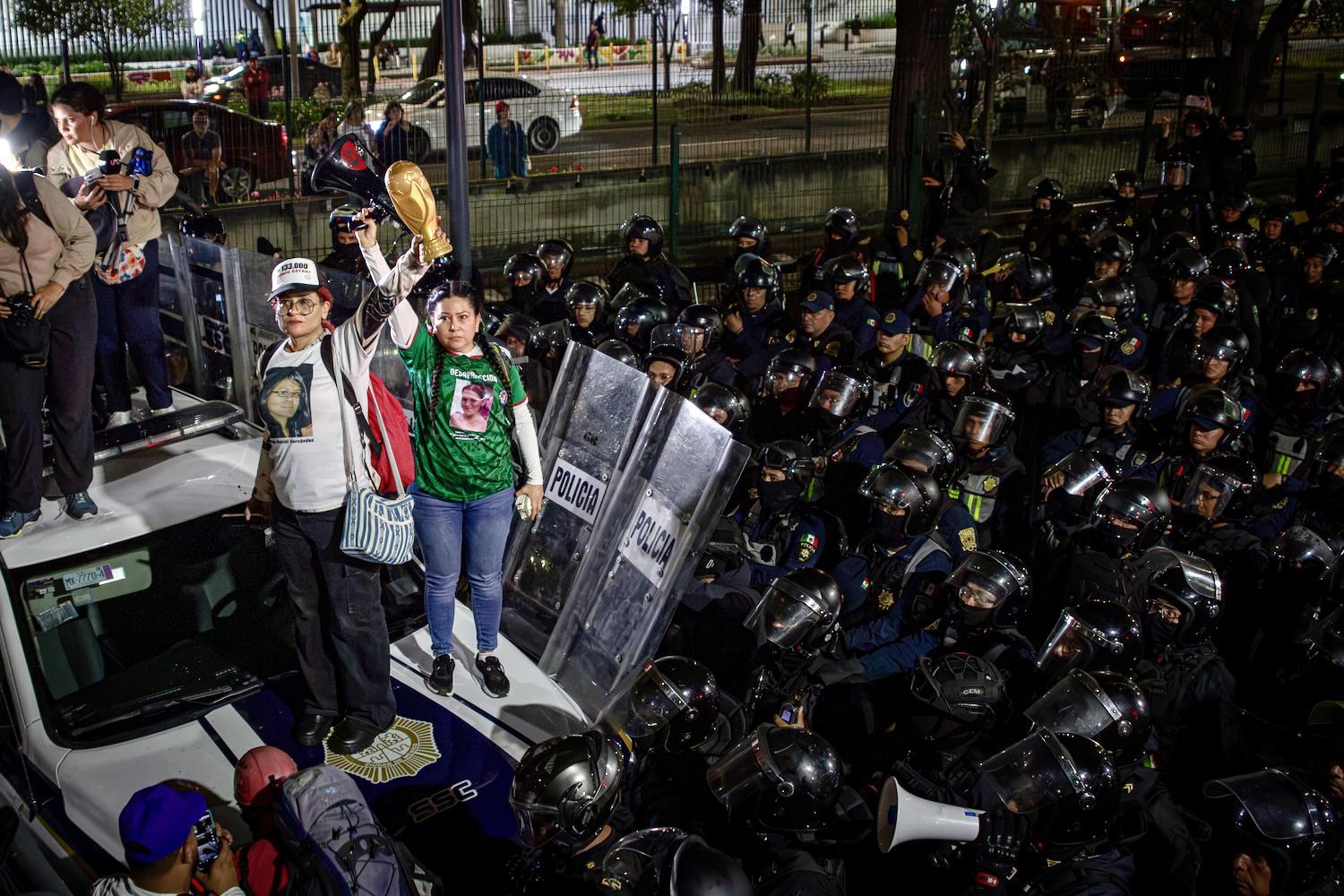$!Tranquilina Hernández levanta su copa mundial frente al contingente de policías.