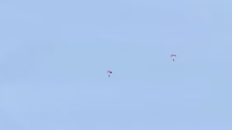 Se ven dos paracaidistas cayendo desde un avión Hércules sobre Fort Smith, como parte del llamado de emergencia tras el siniestro.