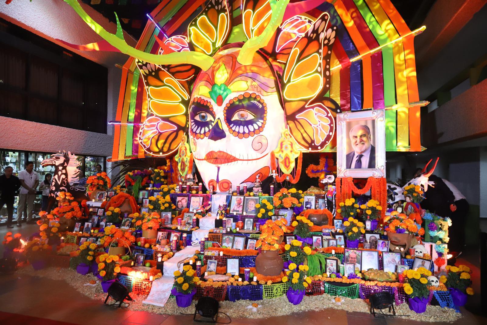 $!El altar está compuesto por papel picado, calaveras, veladoras, frutas frescas, bebidas, como vodka y whisky, evocando los gustos personales del homenajeado y fotografías del empresario y colaboradores que ya partieron de este mundo.