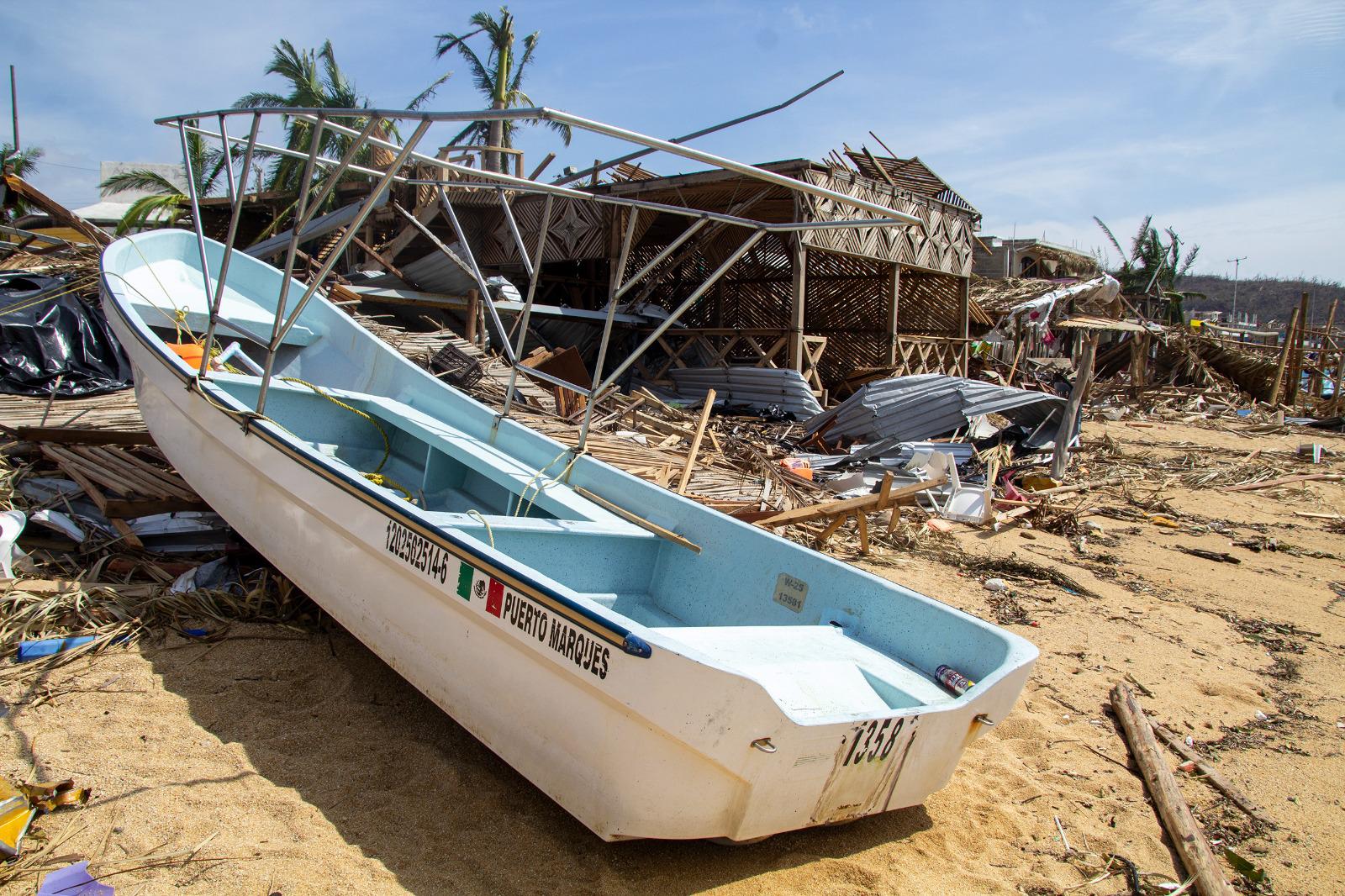 $!Una lancha pesquera sobre la franja de arena, expulsada del mar por los fuertes vientos del huracán Otis.