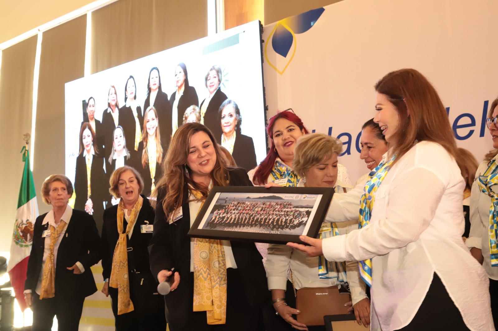 $!Elizabeth Peraza, directora ejecutiva del Grupo Noroeste y coordinadora general del evento, hace entrega de la foto oficial de la Junta Nacional de Anspac Mazatlán 2025, a Martha González Pérez, presidenta del Comité Nacional.