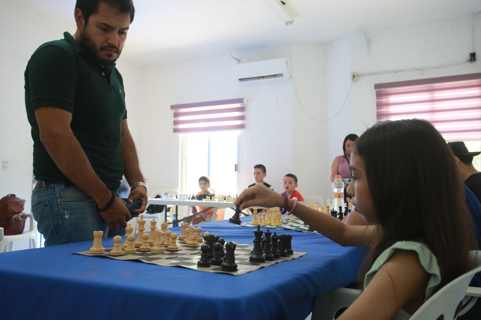 $!El candidato a maestro y quien realizó una Exhibición de Simultáneas, Hiram de Jesús Velarde Ramírez, aquí junto a la niña Gabriela Nataly Soltero Casas.