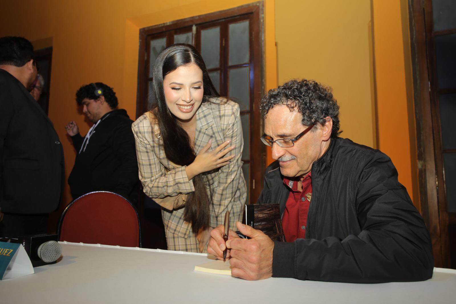 $!Siu Ling Chío Cotero, Reina de los Juegos Florales del Carnaval 2024, le pide un autógrafo al escritor laureado.