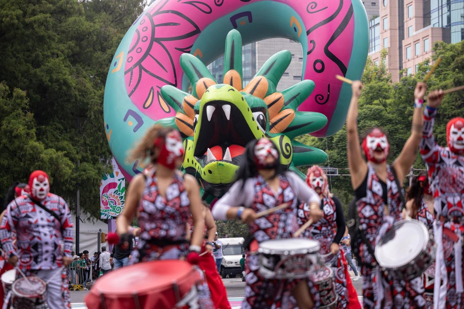 $!Entre danzas y carros alegóricos: turistas y aficionados ven el Desfile Mundialista sobre Paseo de la Reforma