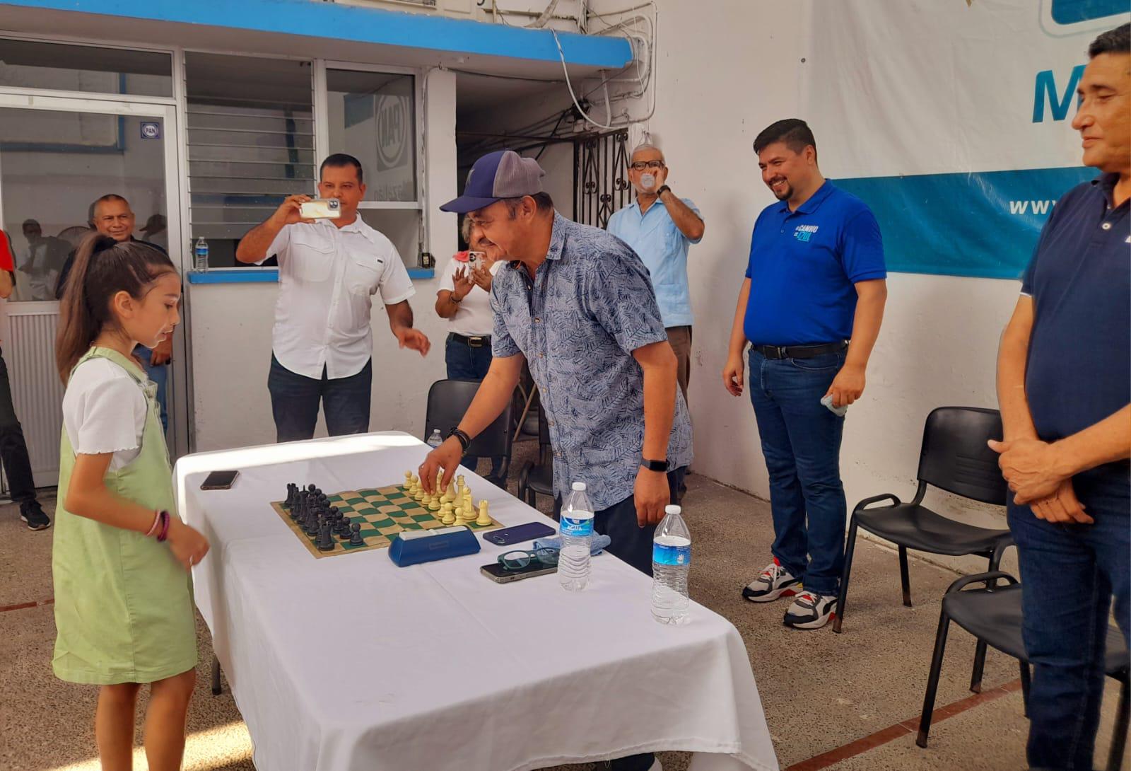 $!La pequeña Gabriela Nataly Soltero y el panista Refugio Gastélum realizaron el primer movimiento del tablero.