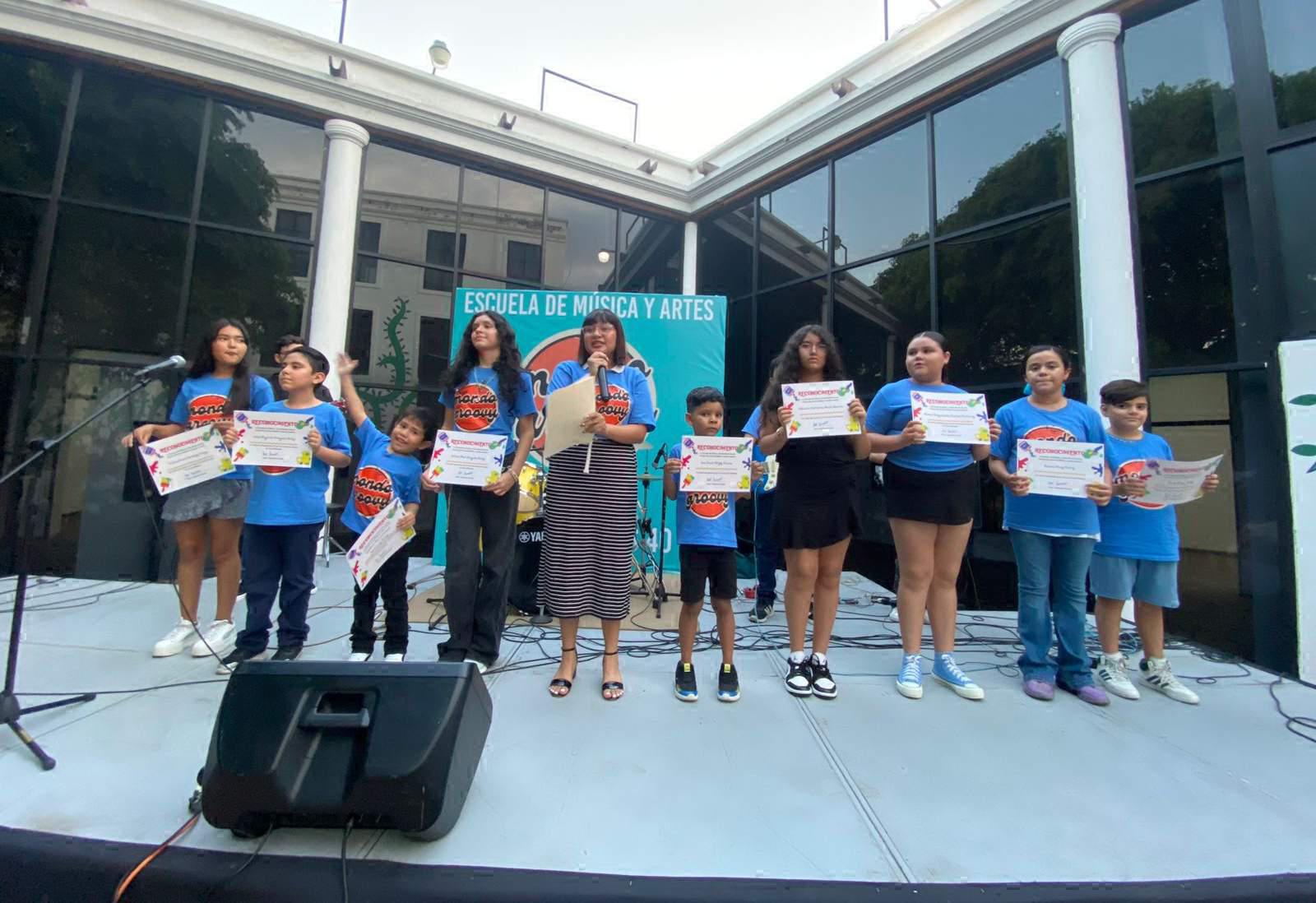 $!La maestra de artes Alejandra Arreola hace entrega de diplomas a sus alumnos.