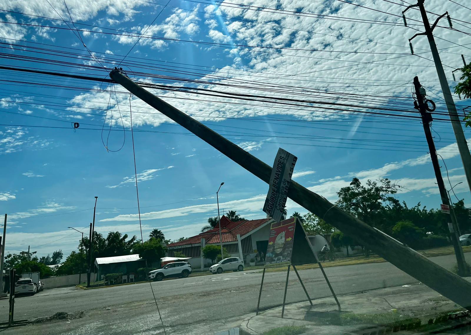 $!Poste queda sostenido por cables y genera riesgo vial en Infonavit Playas, en Mazatlán