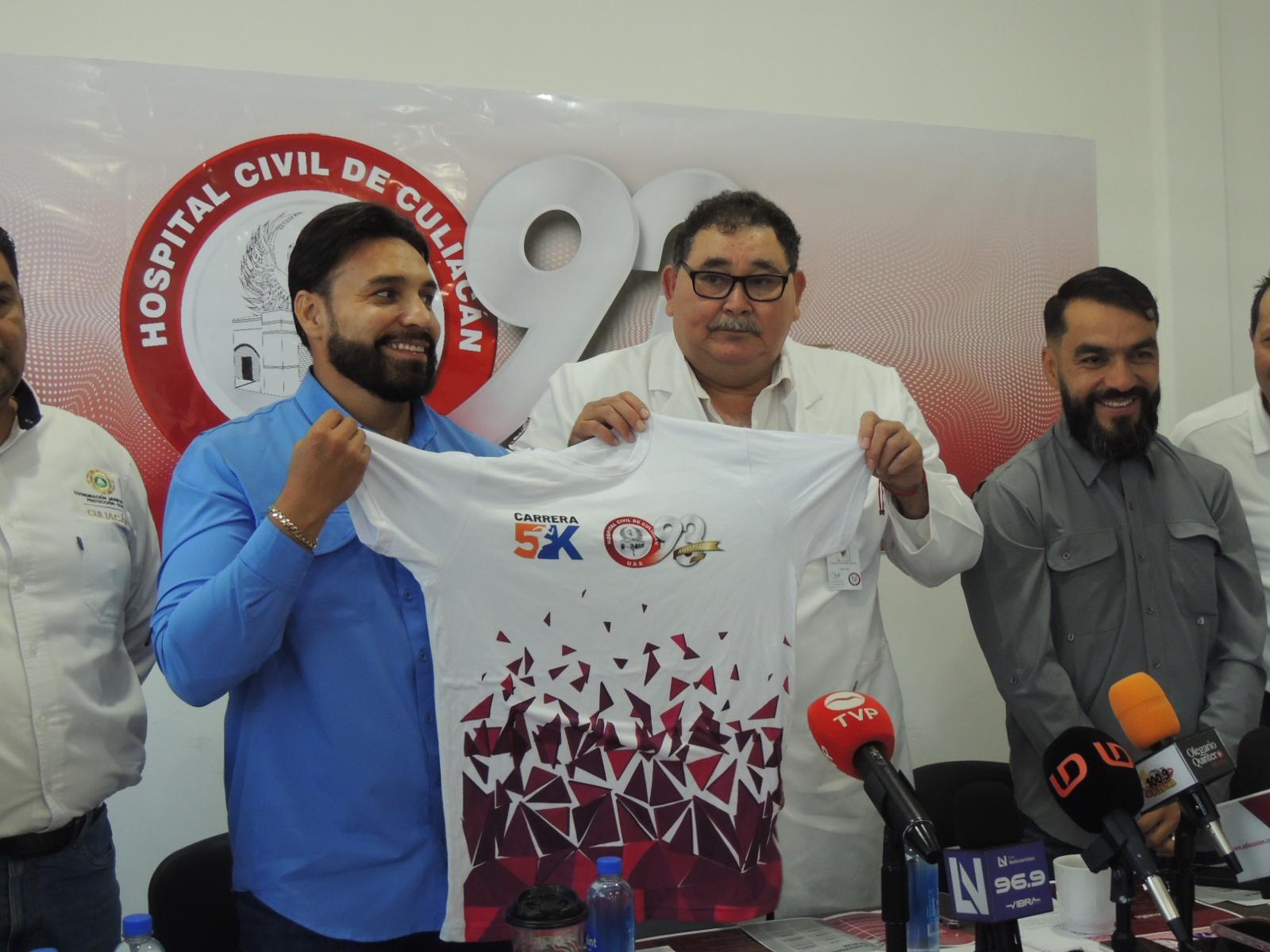 $!Julio César Cascajares y el director del CC presentan la playera oficial de la carrera.