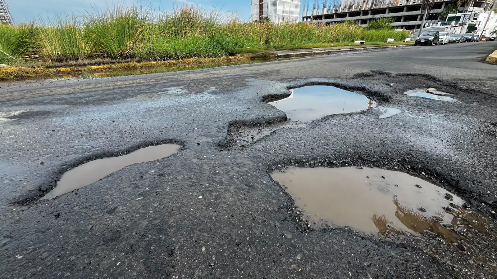 $!Desfogan agua de la Avenida Insurgentes tras limpieza del ducto de la Laguna del Camarón, pero brotan los baches
