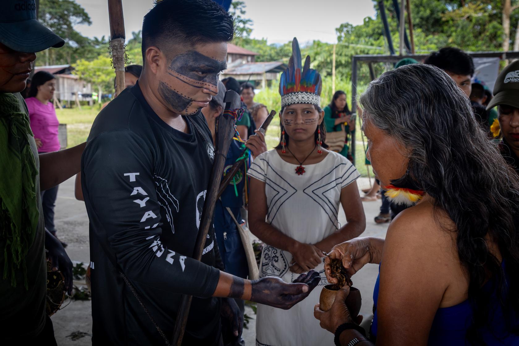$!María de Jesús, centro, hace fila para recibir tabaco ritual shuar en un encuentro de guardias indígenas en Ecuador.