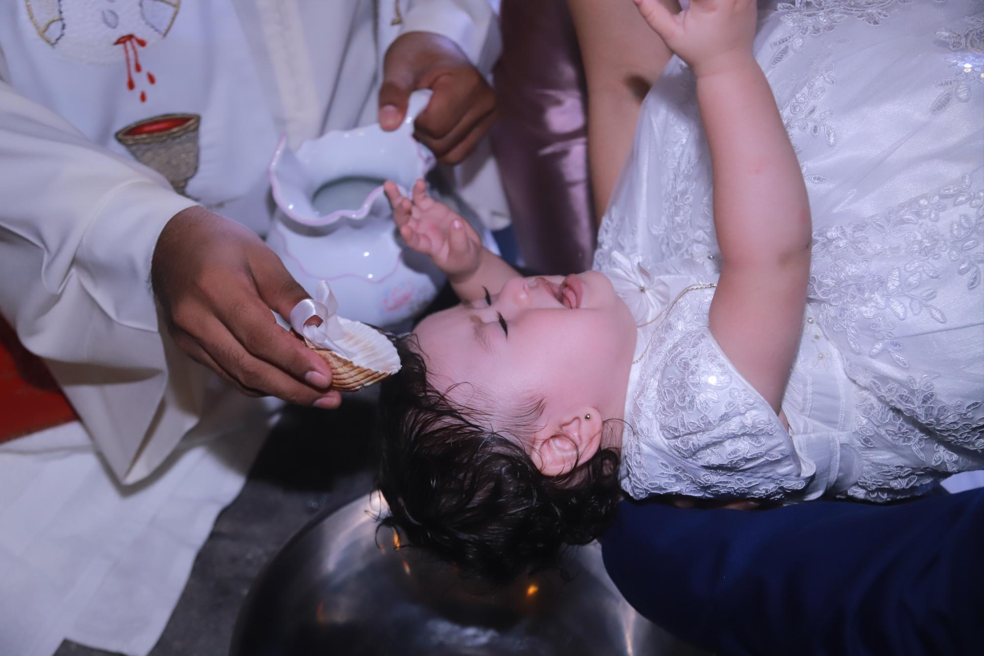 $!La pequeña al momento de recibir las aguas benditas del Jordán.